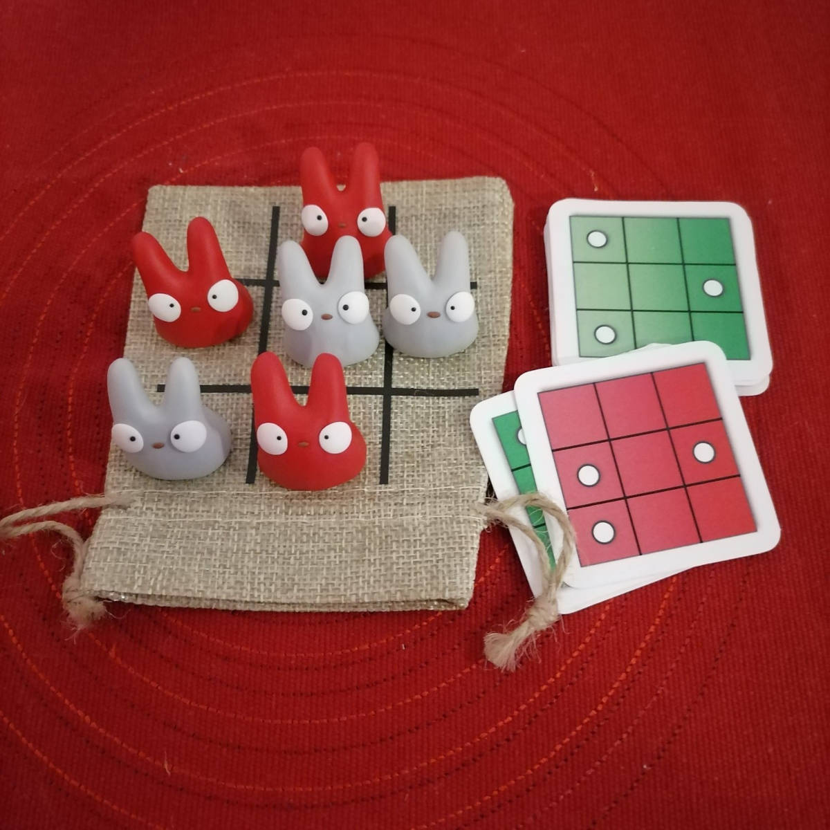 Onni-peli kangaspussilla - harmaat ja punaiset hahmot